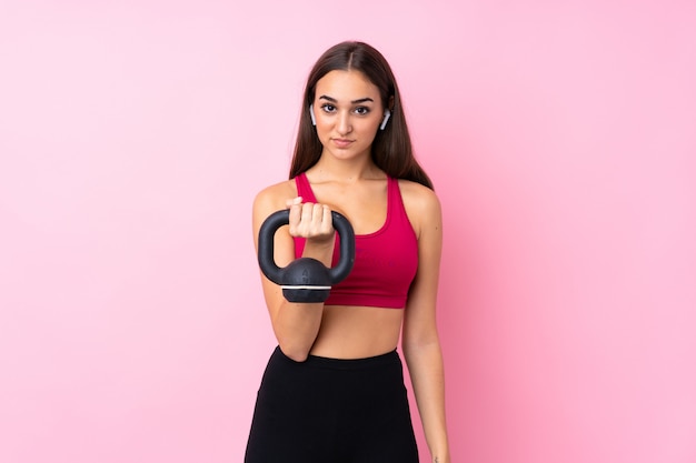 Jeune femme sport faisant de l'haltérophilie avec kettlebell et regardant vers l'avant