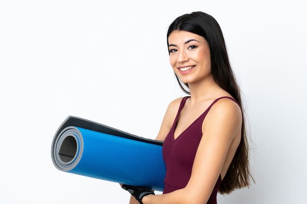 Jeune femme sport sur mur blanc avec un tapis