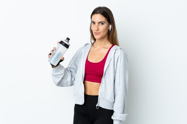 Jeune femme sport sur mur avec bouteille d'eau de sport