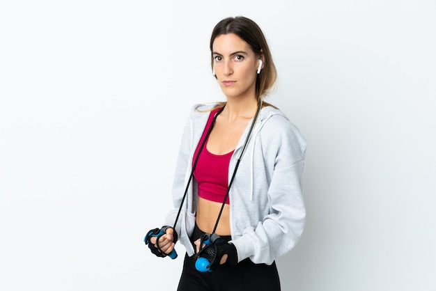 Jeune femme sport sur mur avec corde à sauter