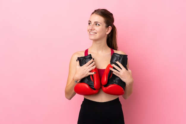 Jeune femme sport sur mur rose isolé avec des gants de boxe