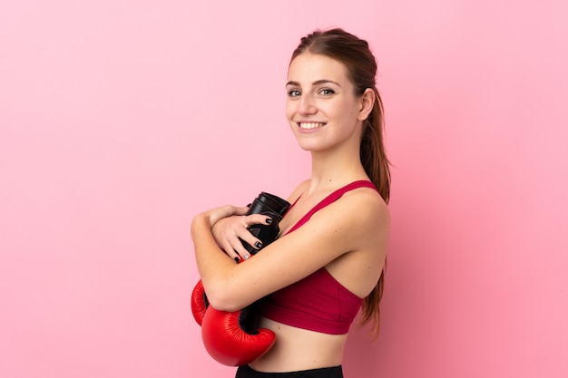 Jeune femme sport sur mur rose isolé avec des gants de boxe