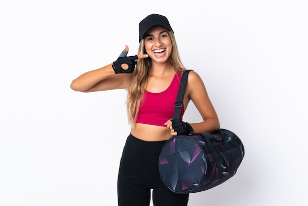 Jeune femme de sport avec sac de sport sur blanc isolé donnant un geste de pouce en l'air