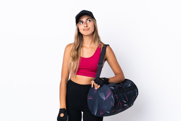 Jeune femme de sport avec sac de sport sur fond blanc isolé et levant