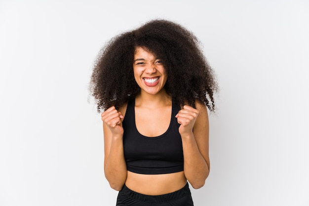 Jeune femme sportive afro-américaine acclamant insouciant et excité.