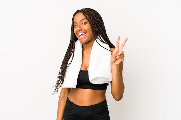 Jeune femme sportive afro-américaine isolée joyeuse et insouciante montrant un symbole de paix avec les doigts.