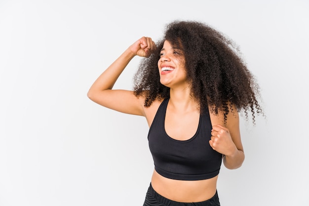 Jeune femme sportive afro-américaine, levant le poing après une victoire, concept gagnant.