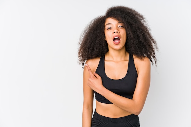 Jeune femme sportive afro-américaine pointant vers le côté