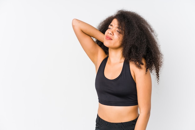 Jeune femme sportive afro-américaine touchant l'arrière de la tête, en pensant et en faisant un choix.