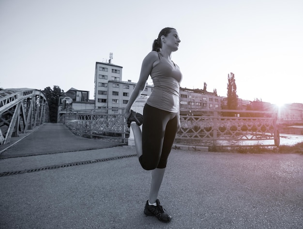 jeune femme sportive faisant du jogging sur le pont le matin ensoleillé de la ville