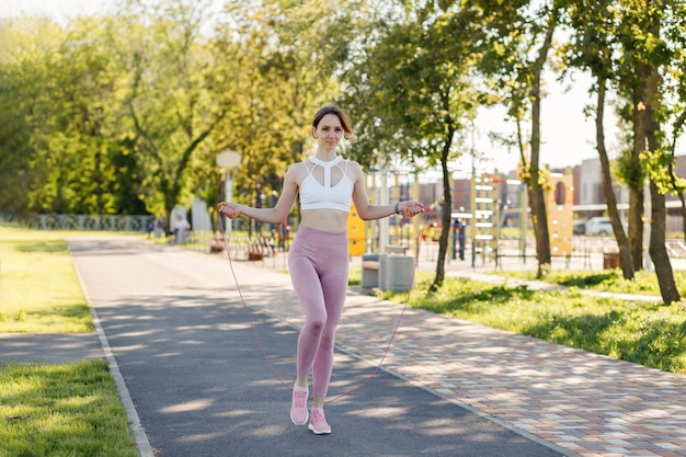 Jeune femme sportive faisant des exercices de fitness en plein air