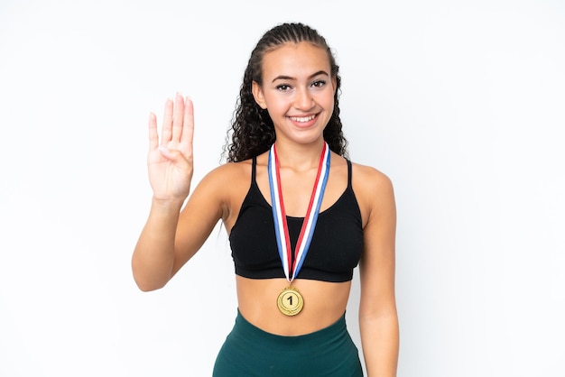 Photo jeune femme sportive avec des médailles isolées sur fond blanc heureuse et comptant quatre avec les doigts