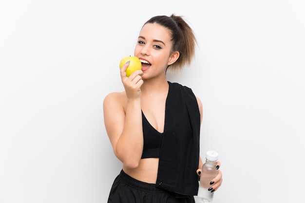 Jeune femme sportive sur un mur blanc avec une pomme