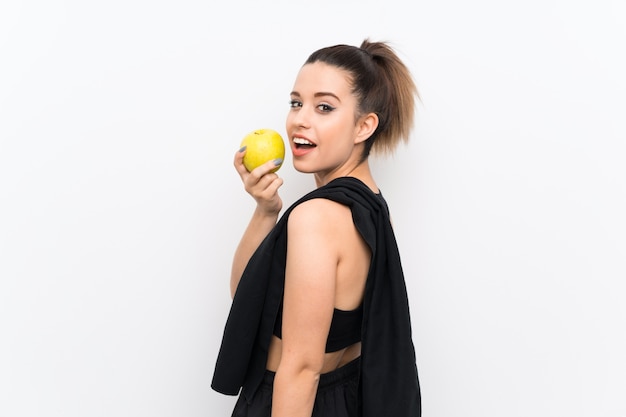 Jeune femme sportive sur un mur blanc avec une pomme