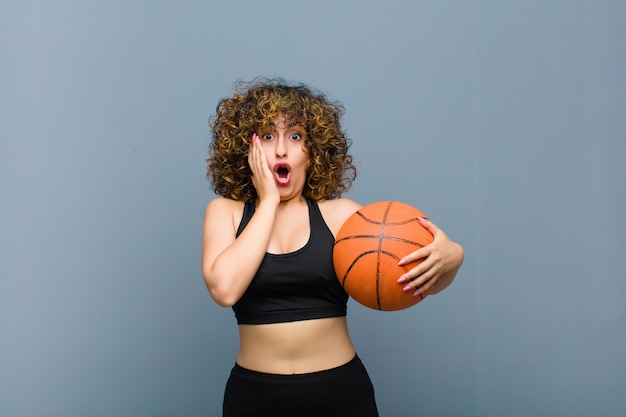 Jeune femme sportive portant des vêtements de fitness avec un ballon de basket