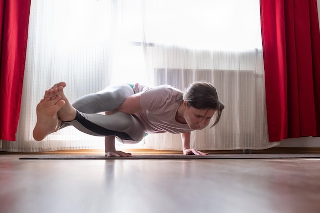 Jeune femme sportive pratiquant le yoga faisant le bras debout Astavakrasana