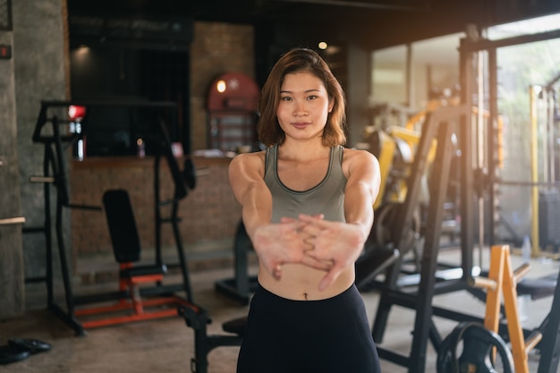 Jeune femme sportive qui s'étend au gymnase, concept de sport de remise en forme