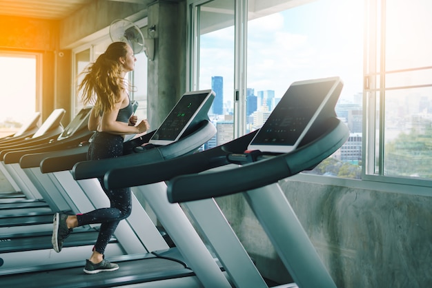 Jeune femme sportive qui s&#39;étend au gymnase