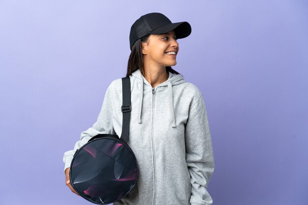 Jeune femme sportive avec sac de sport à la recherche sur le côté