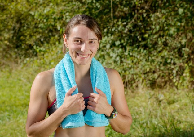 Jeune femme sportive avec une serviette bleue à la campagne