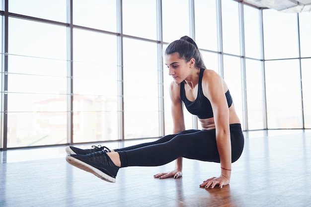 Jeune femme sportive en tenue de sport faisant du fitness dans la salle de gym.