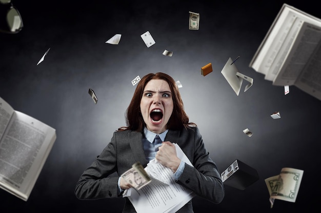 Photo jeune femme stressée folle au travail, déchirant des documents avec une expression faciale frustrée. technique mixte