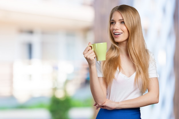Jeune femme en studio boit du café ou du thé