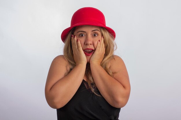 Jeune femme en studio photo avec des expressions faciales et avec un chapeau rouge