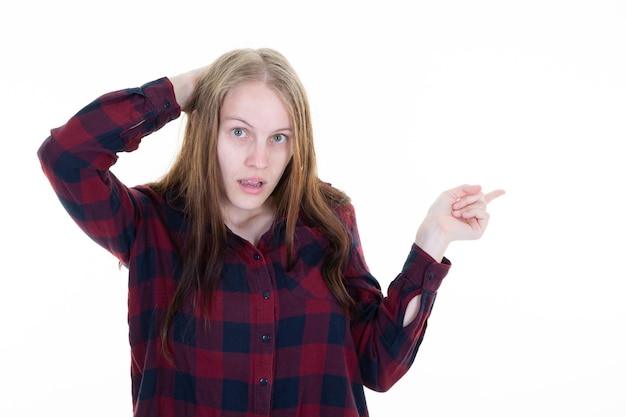 Jeune femme surprise pointant du doigt côté copie espace blanc fond blanc