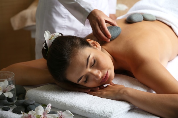 Jeune femme sur table de massage dans un salon de beauté spa