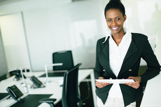 Jeune femme avec tablette au bureau