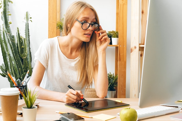 Jeune femme et tablette travaillant au bureau à domicile