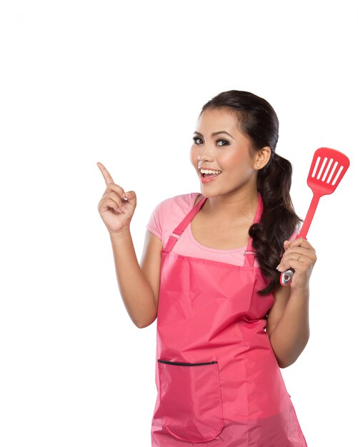 Jeune femme en tablier rose avec spatule