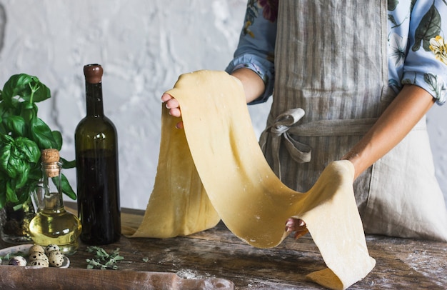 Jeune femme, tablier, tenue, pâte, pâtes maison, à, cuisine rustique