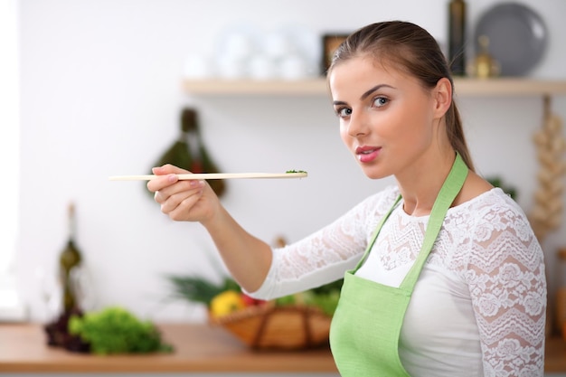 Jeune femme en tablier vert cuisine dans une cuisine