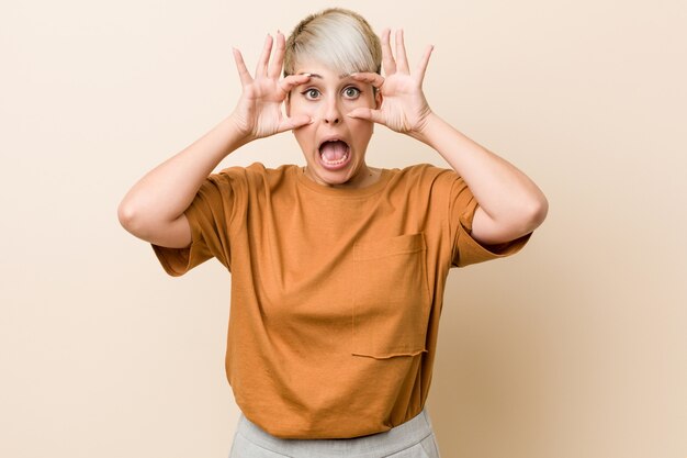 Jeune femme de taille plus aux cheveux courts gardant les yeux ouverts pour trouver une opportunité de succès.