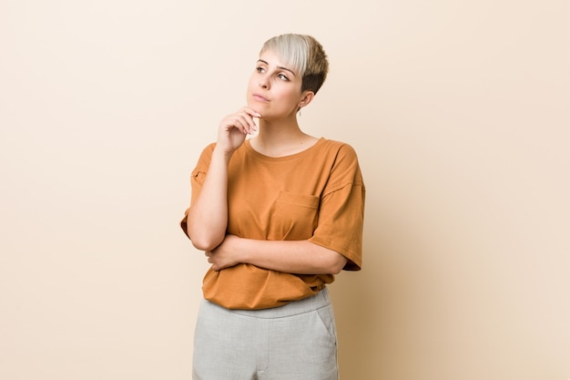 Jeune femme de taille plus avec des cheveux courts à côté avec une expression douteuse et sceptique.