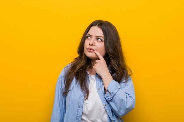 Jeune femme de taille plus sinueuse à côté avec une expression douteuse et sceptique.