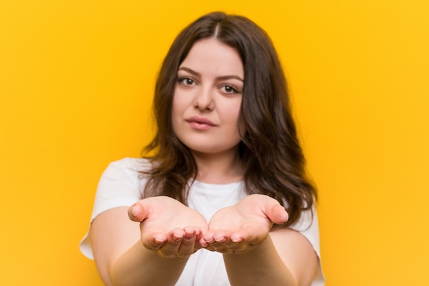 Jeune femme de taille plus sinueuse tenant quelque chose avec des paumes