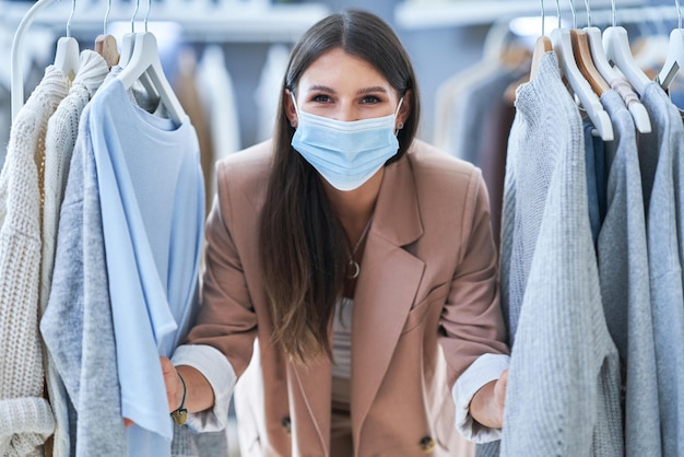 Jeune femme en tant que gérante de magasin avec des vêtements en masque. photo de haute qualité