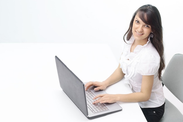 Jeune femme tapant du texte sur un clavier d'ordinateur portable