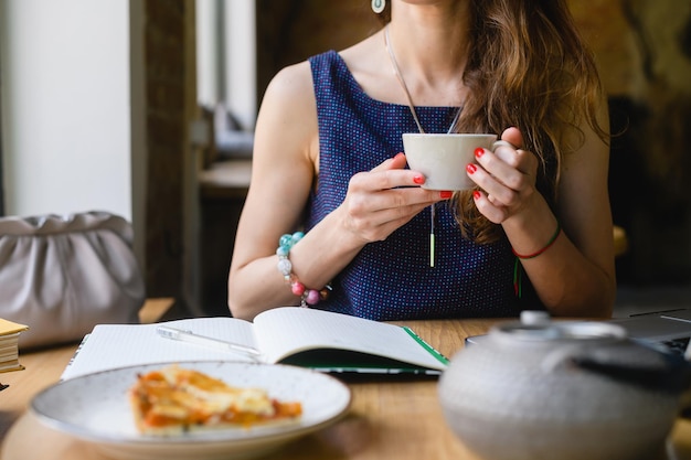 Une jeune femme avec une tasse de thé dans ses mains Gros plan