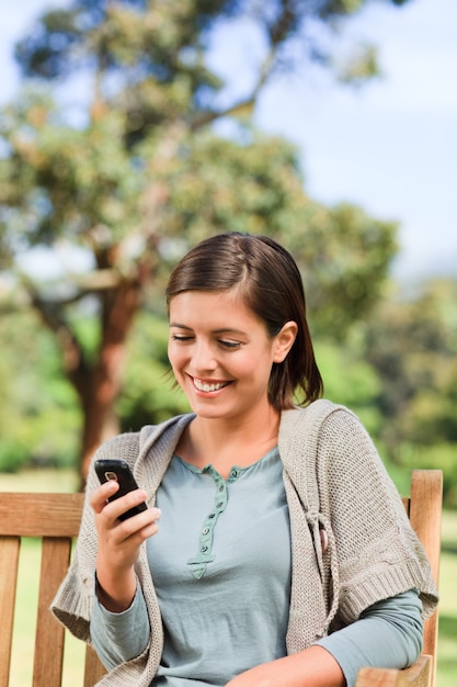 Jeune femme téléphonant sur le banc