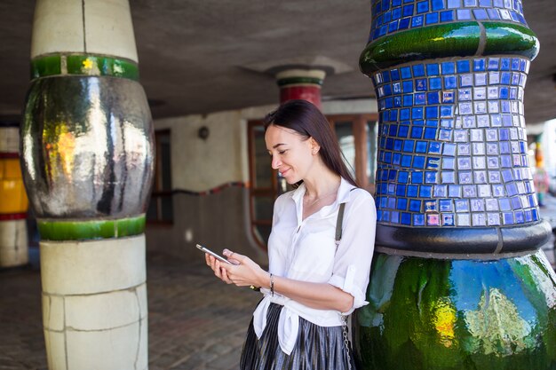 Jeune femme avec téléphone dans la ville européenne.