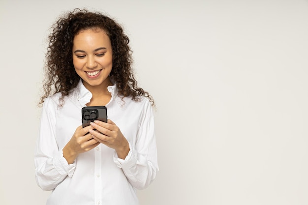 Jeune femme avec téléphone sur fond blanc