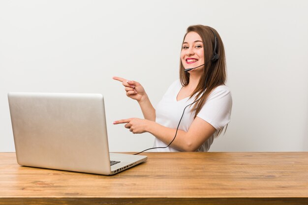 Jeune femme télévendeur excité pointant avec les index loin.