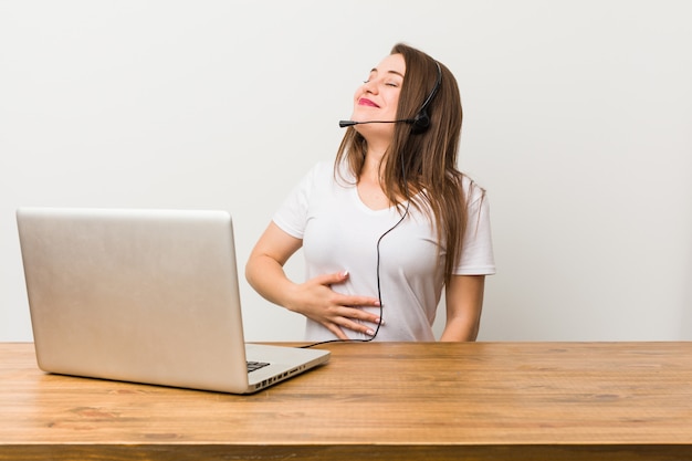 Jeune femme télévendeur touche le ventre, sourit doucement, manger et concept de satisfaction.