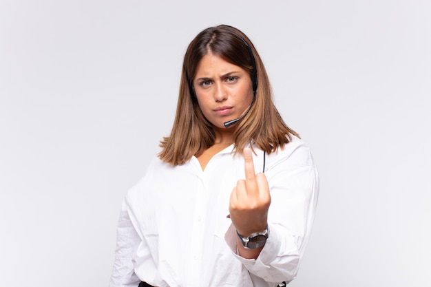 jeune femme télévendeuse se sentant en colère, agacée, rebelle et agressive, renversant le majeur, ripostant