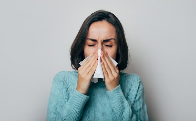 Jeune femme avec une température élevée tousse Femme malade avec grippe et maux de tête Concept d'allergie à la maladie du froid rhinite Coup de toux Épidémie de coronavirus