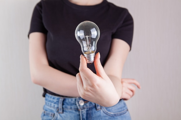 Jeune femme tenant une ampoule dans ses mains